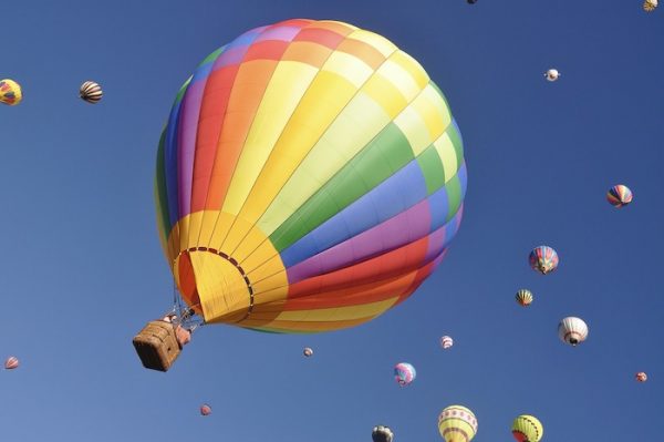Ordnung beim Umzug. Ein bunter Heißluftballon fliegt am blauen Himmel. Ballastfrei umziehen.