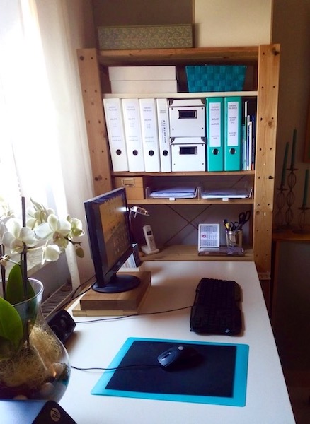 Auf einer weißen Arbeitsplatte steht ein PC, eine Tastatur, eine Maus und eine Orchidee. Mehr nicht. Ordnung am Schreibtisch.